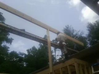 Carpenter setting a ridge beam over a new addition frame — Ice Dam Removal by Roofing Brothers in Bangor