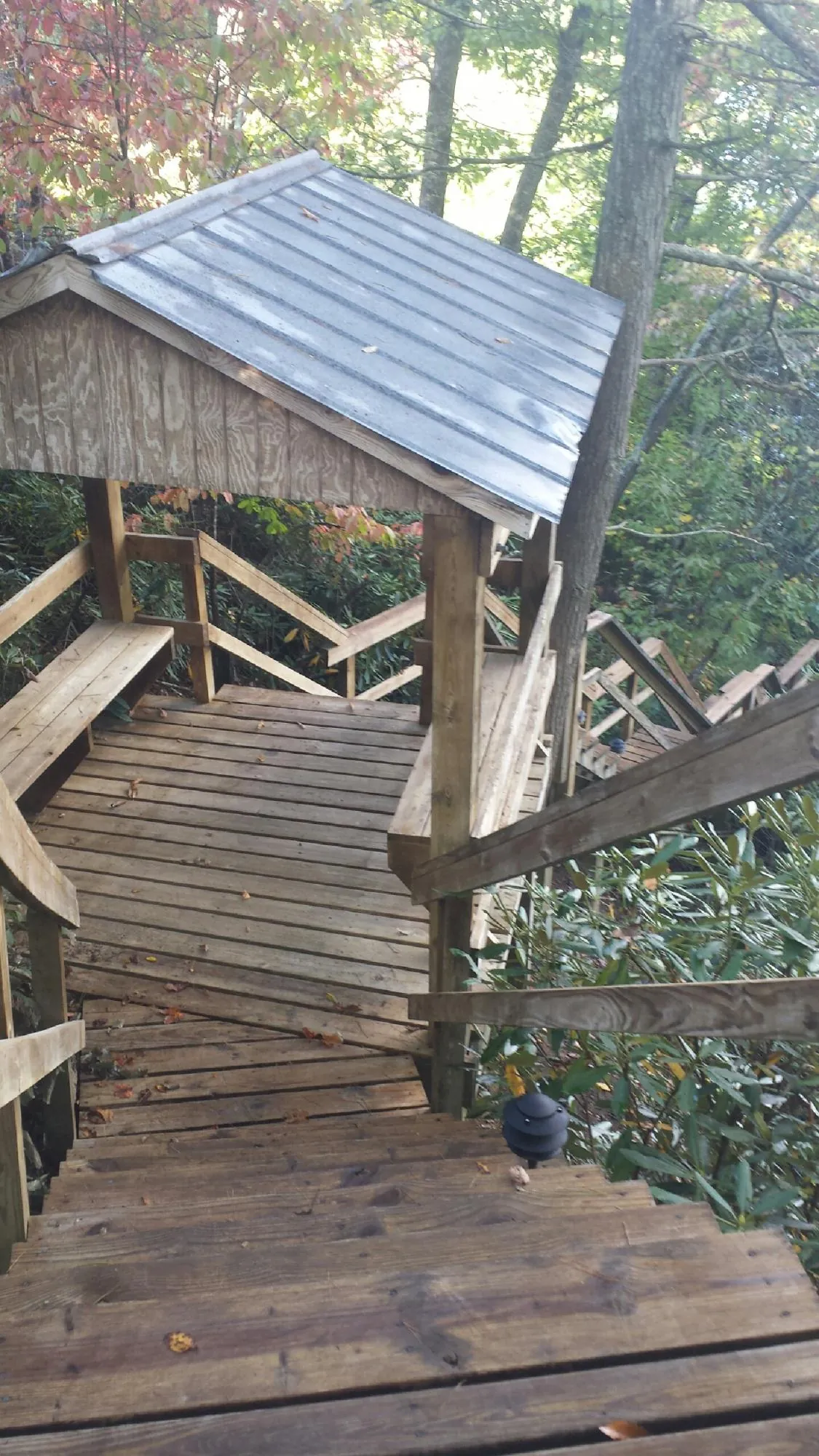 Metal roofed shelter over wooden steps on a wooded walkway — Skylight Repair & Installation work by our crew in Bangor