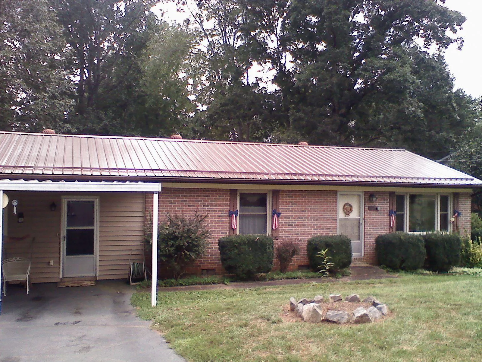 Bronze metal roof and carport on a brick ranch home — Roof Repair work by our crew in Bangor